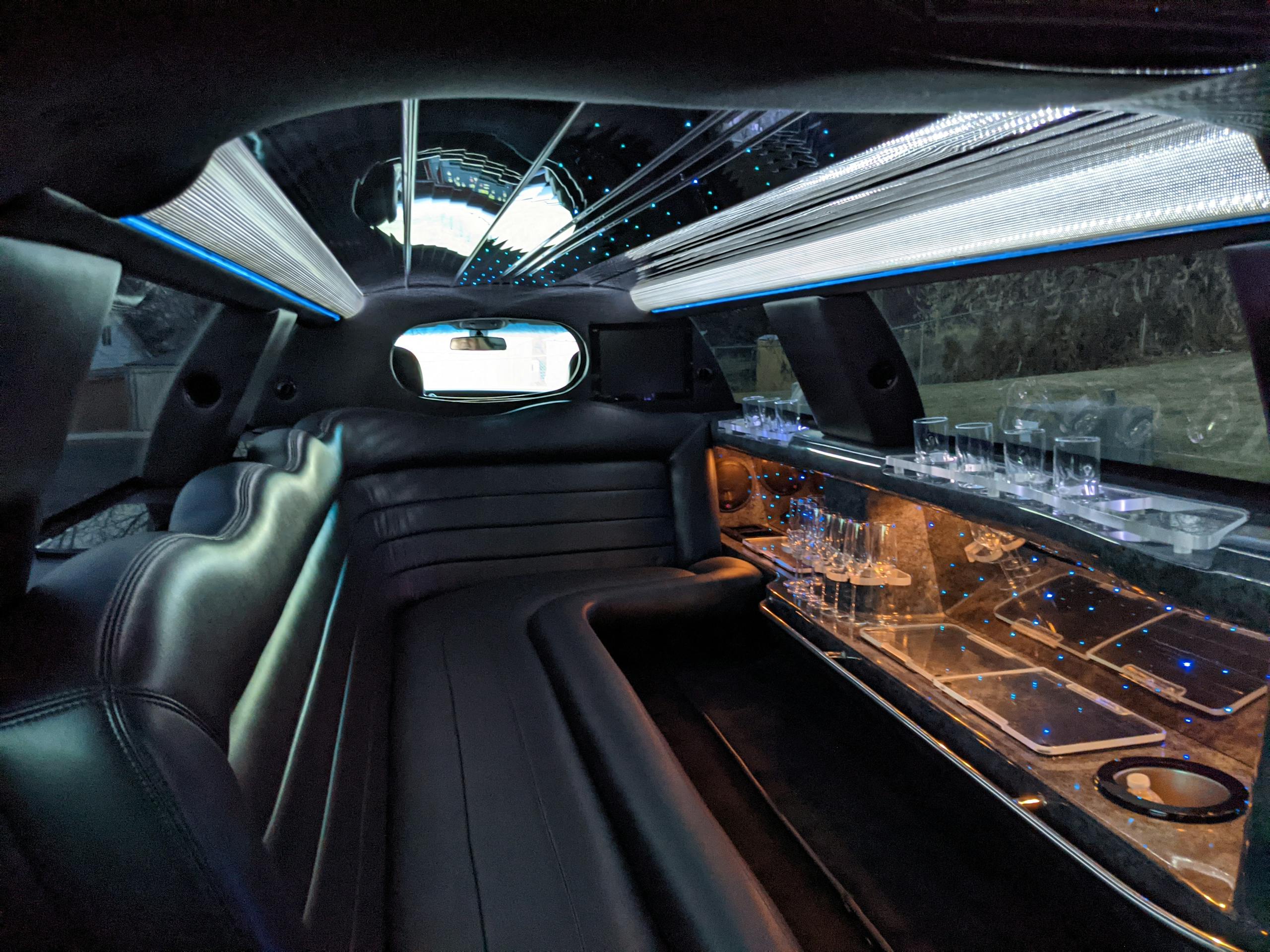 Explore the plush interior of a luxury limousine featuring ambient lighting and comfortable seating.